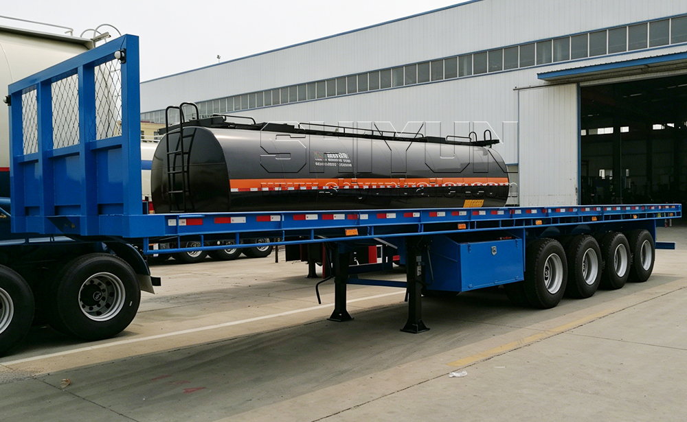 Blue flatbed trailer carrying tank load