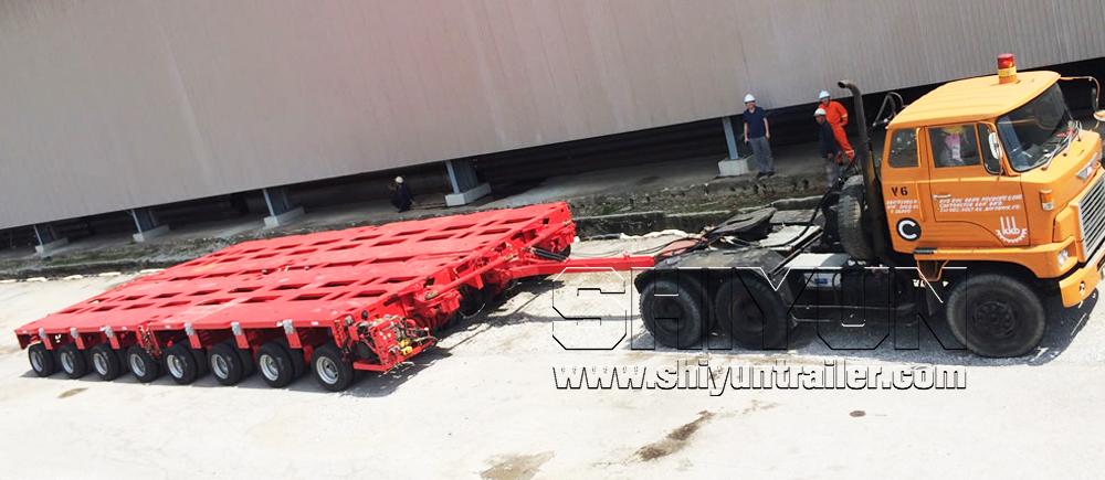 Red modular trailer axle lines being towed by truck