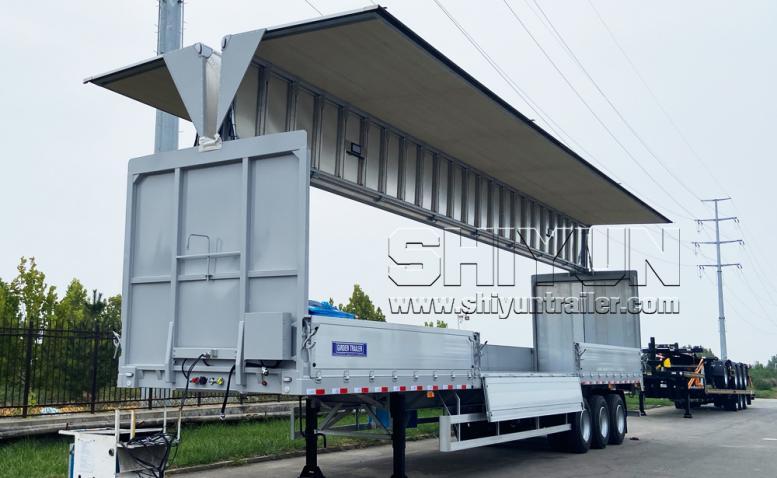 Gray wing van trailer with wing panel open