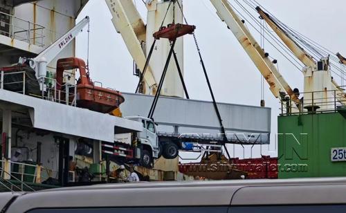 Crane lifting trailer chassis for shipment