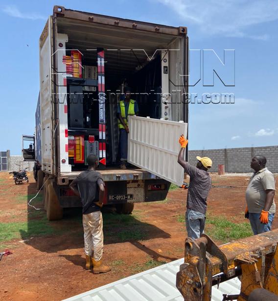 Workers loading trailer parts into container