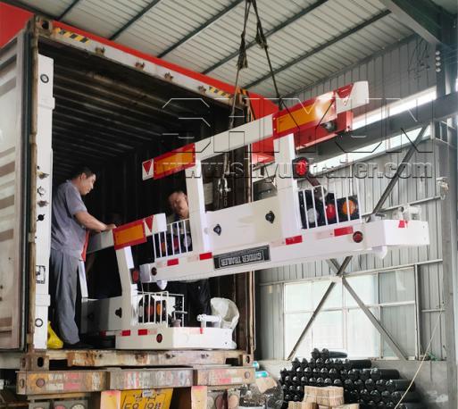 Workers loading trailer sections into container