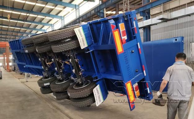 Blue flatbed trailer being loaded intact