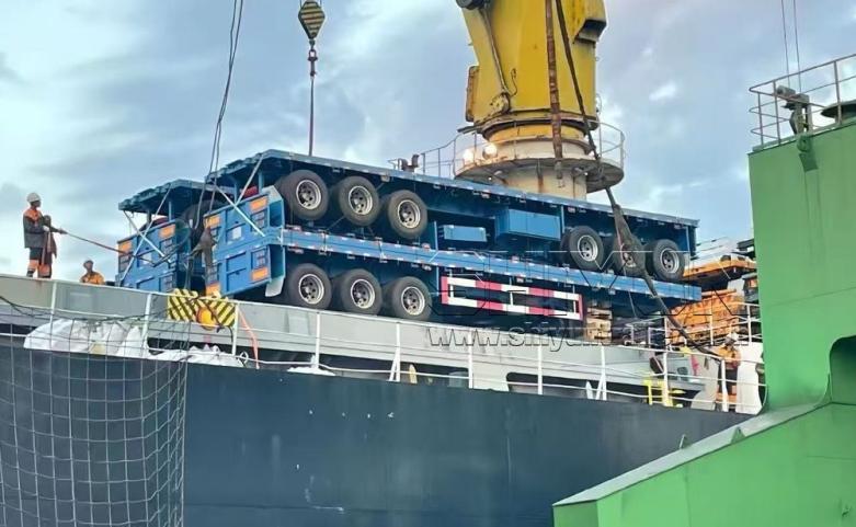 Trailer lifted by crane onto bulk carrier ship