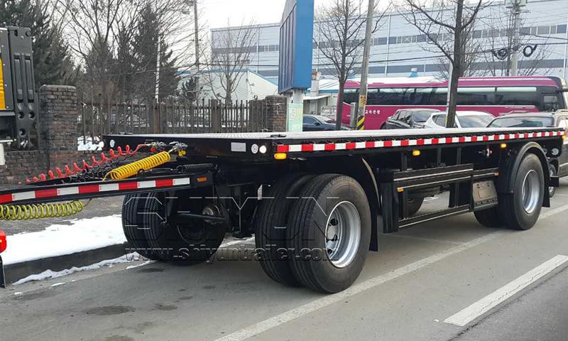 Flatbed draw bar trailer loaded on snowy road